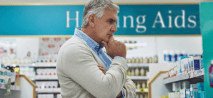 a mature white man at a convenient store looking at hearing aids